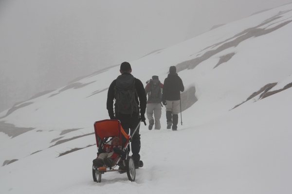 auf winterwanderung mit Kind in den alpen warm eingepackt